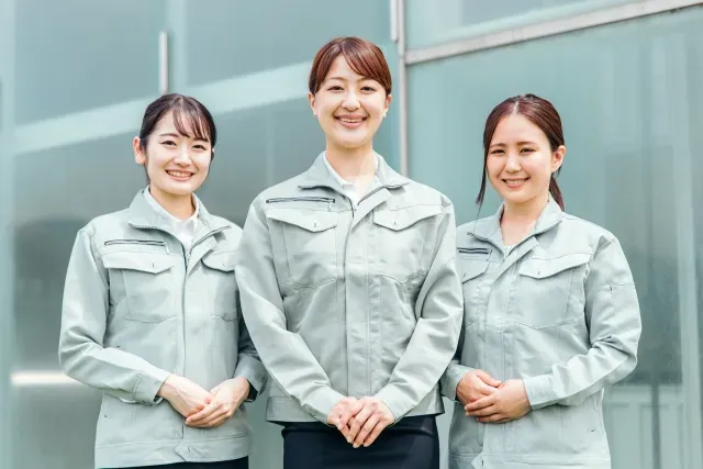 作業着姿の3人が並んで立っているイメージ写真